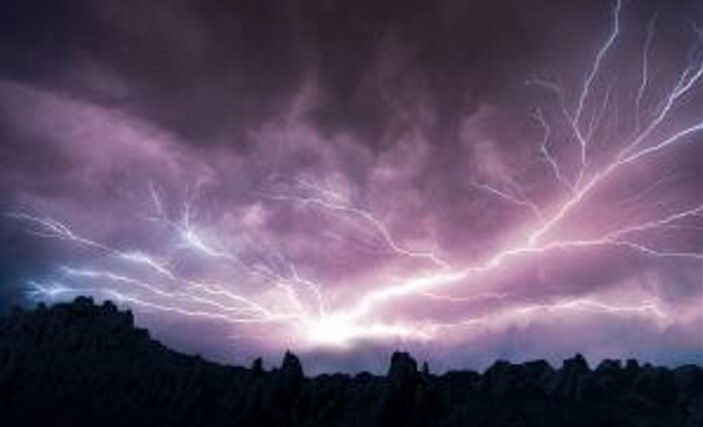 Sky at night, lit up by lightning.